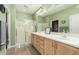 Bathroom featuring double sinks, light-colored cabinets, and a glass shower at 26237 W Vista North Dr, Buckeye, AZ 85396