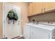 Functional laundry room with appliances, storage cabinets, and exterior access door at 26237 W Vista North Dr, Buckeye, AZ 85396