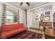 Stylish office featuring a red futon, patterned rug, and large window with natural light at 26237 W Vista North Dr, Buckeye, AZ 85396