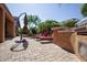Outdoor back patio with grill, stone countertop, red patio furniture and well-manicured landscaping at 26293 W Runion Ln, Buckeye, AZ 85396