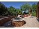 Relaxing backyard area featuring a fire pit, built-in seating, and lush tropical landscaping at 26293 W Runion Ln, Buckeye, AZ 85396