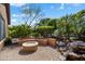 Cozy backyard patio area with firepit, built in seating, and lush landscaping at 26293 W Runion Ln, Buckeye, AZ 85396