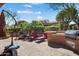 This backyard features mature plants, an outdoor grill area, and two red lounge chairs at 26293 W Runion Ln, Buckeye, AZ 85396