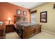 Well-lit bedroom featuring dark wooden furniture, a queen-sized bed, and warm-toned walls at 26293 W Runion Ln, Buckeye, AZ 85396