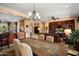 Open-concept dining room leads to living space, showcasing a tiled wood table with chandelier at 26293 W Runion Ln, Buckeye, AZ 85396