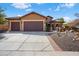 Charming single-story home with a well-manicured yard and three-car garage under a blue sky at 26293 W Runion Ln, Buckeye, AZ 85396