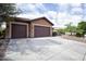 Spacious driveway leading to a well-maintained home with a landscaped front yard featuring desert plants and mature tree at 26293 W Runion Ln, Buckeye, AZ 85396