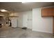Spacious garage featuring a refrigerator, storage shelving, and access to the house at 26293 W Runion Ln, Buckeye, AZ 85396