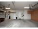 Cluttered garage featuring an water heater, water softener, shelving and a refrigerator at 26293 W Runion Ln, Buckeye, AZ 85396