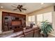 Comfortable living room features a custom built-in media center and a leather sofa and chair set at 26293 W Runion Ln, Buckeye, AZ 85396