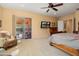 This main bedroom features a wooden bed frame, ceiling fan, television, and access to the backyard at 26293 W Runion Ln, Buckeye, AZ 85396