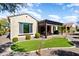 Exterior view of a well-kept home, featuring a covered patio, manicured lawn, and mature landscaping at 26797 W Sierra Pinta Dr, Buckeye, AZ 85396