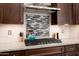 Close-up of a gourmet kitchen featuring granite counters, cooktop, and stainless steel hood at 26797 W Sierra Pinta Dr, Buckeye, AZ 85396