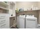 Functional laundry room with modern washer, dryer, and built-in shelving at 26797 W Sierra Pinta Dr, Buckeye, AZ 85396