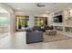 Open living room featuring a modern sofa, built-in shelving, and sliding glass doors to the patio at 26797 W Sierra Pinta Dr, Buckeye, AZ 85396