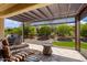 Beautiful covered patio featuring a built-in grill, ample seating, and a peaceful view of the lush backyard at 26797 W Sierra Pinta Dr, Buckeye, AZ 85396