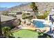 A relaxing backyard featuring a pool with a rock waterfall feature, a putting green, and mountain views at 2813 W Hiddenview Dr, Phoenix, AZ 85045