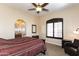 Comfortable bedroom with arched entry to bathroom, ceiling fan, and natural light from the window at 2813 W Hiddenview Dr, Phoenix, AZ 85045