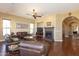 Comfortable living room with a ceiling fan, fireplace, hardwood floors, and abundant natural light at 2813 W Hiddenview Dr, Phoenix, AZ 85045