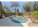 Picturesque backyard with a freeform pool surrounded by mature trees and lush landscaping at 4308 E Smokehouse Trl, Cave Creek, AZ 85331