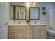 Bright bathroom boasts double vanity with a tile countertop, framed mirrors, and ample lighting at 5618 W Blackhawk Dr, Glendale, AZ 85308