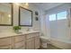 Well-lit bathroom features a double vanity, tile countertop, decorative mirrors, and a shower-tub combination at 5618 W Blackhawk Dr, Glendale, AZ 85308