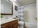 Cozy bathroom featuring a single vanity with wood-tone cabinetry and a shower-tub combination with curtain at 5618 W Blackhawk Dr, Glendale, AZ 85308