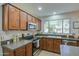 Updated kitchen with dark wood cabinets, granite countertops, and stainless steel appliances at 5618 W Blackhawk Dr, Glendale, AZ 85308