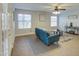 Cozy living room featuring tile floors, a ceiling fan, and a comfortable blue sofa with bright natural light at 5618 W Blackhawk Dr, Glendale, AZ 85308