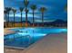 Tranquil community pool illuminated at twilight, reflecting the serene desert landscape and providing an evening oasis at 5812 E Sanford St, Mesa, AZ 85215