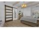 Bright main bedroom with wood floors, ceiling beams, sliding barn door and modern chandelier at 5812 E Sanford St, Mesa, AZ 85215