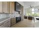 Well-lit kitchen with wooden cabinets, black oven, range hood, marble countertops and view to living room at 7705 E Doubletree Ranch Rd # 21, Scottsdale, AZ 85258