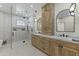 Bright main bathroom showcasing wood cabinets, marble counters, dual sinks, and a glass shower at 7705 E Doubletree Ranch Rd # 21, Scottsdale, AZ 85258