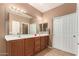 Bathroom with dual sink vanity, large mirror, neutral paint and tile floors at 10414 W Windsor Ave, Avondale, AZ 85392