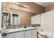 Well-lit bathroom with a large mirror, a granite countertop, and a shower-tub combo at 10414 W Windsor Ave, Avondale, AZ 85392