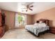 Bedroom with tile floors, neutral paint, ceiling fan and an exterior view at 10414 W Windsor Ave, Avondale, AZ 85392