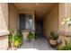 Charming covered front porch with neutral colors and lush greenery in decorative pots for added curb appeal at 10414 W Windsor Ave, Avondale, AZ 85392