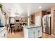 Open-concept kitchen with stainless steel appliances, granite countertops, and an adjacent living and dining area at 10414 W Windsor Ave, Avondale, AZ 85392