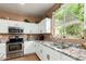 Bright kitchen showcasing white cabinetry, granite countertops, stainless steel appliances, and a large window at 10414 W Windsor Ave, Avondale, AZ 85392