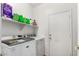 Functional laundry room with washer, dryer, shelving, and neutral paint at 10414 W Windsor Ave, Avondale, AZ 85392