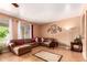 Bright living room featuring tile floors, a sectional sofa, and ample natural light at 10414 W Windsor Ave, Avondale, AZ 85392