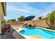 Beautiful backyard pool with blue umbrella and desert landscaping at 10414 W Windsor Ave, Avondale, AZ 85392