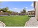 Large backyard with green grass, stone landscaping, and a covered patio area at 1093 E Doral Ave, Gilbert, AZ 85297