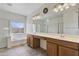 Bright bathroom features a double vanity, large mirror, separate shower, and soaking tub with a window view at 1093 E Doral Ave, Gilbert, AZ 85297