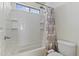 Bathroom with a tub, shower, tiled walls, and a patterned shower curtain with a bright window at 1093 E Doral Ave, Gilbert, AZ 85297