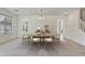 Open dining room with a light wood table, six chairs, and ample natural light from large windows at 1093 E Doral Ave, Gilbert, AZ 85297