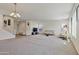 Bright open-concept living room with soft carpet, modern furniture, and plenty of space at 1093 E Doral Ave, Gilbert, AZ 85297