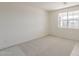 Bright bedroom with neutral carpet, a large window, and fresh white paint at 11300 N Casa Dega Dr # 1044, Surprise, AZ 85388