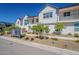 Modern townhome showcases a crisp white facade, inviting balconies, and drought-tolerant landscaping under a clear blue sky at 11300 N Casa Dega Dr # 1044, Surprise, AZ 85388