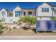 A wide exterior shot of a bright white townhome complex with landscaped walkways at 11300 N Casa Dega Dr # 1044, Surprise, AZ 85388